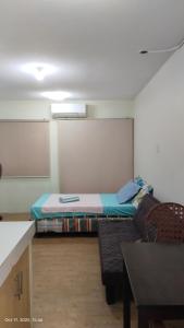 a room with a bed and a couch in it at Hanna's Condo at Sanremo Oasis in Cebu City