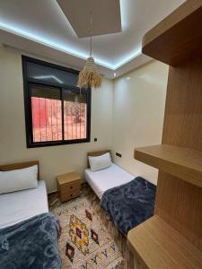 a room with two beds and a window at Breeze surf lodge in Tamraght Ouzdar