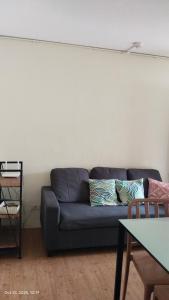 a couch in a living room with a white wall at Hanna's Condo at Sanremo Oasis in Cebu City