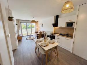 a kitchen and living room with a table and chairs at Lumen Chartrain - appartement proche centre-ville, balcon et parking in Chartres