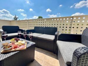a table with a tray of food and glasses of wine at Lumen Chartrain - appartement proche centre-ville, balcon et parking in Chartres