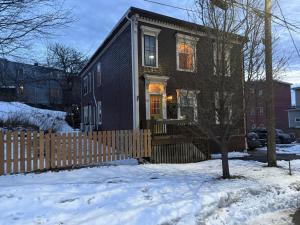 a house with a wooden fence in the snow at Nigam's Sweet Home in Saint John