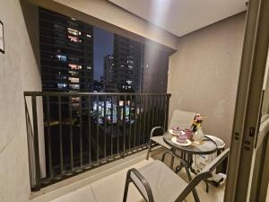 a balcony with a table and chairs and a city skyline at Studio Itaú Metrô Conceição in São Paulo