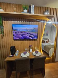 a room with a table and a tv on a wall at Studio Itaú Metrô Conceição in São Paulo