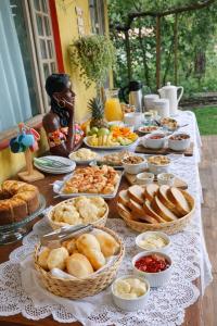 a table topped with lots of different types of food at Pousada Raízes do Cipó in Serra do Cipo +18 photos