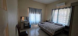 a bedroom with a bed and a desk and window at Homey Haven in Willemstad