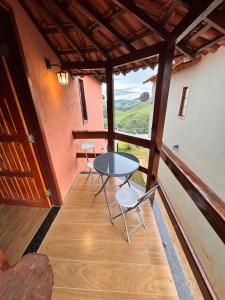 a table and chairs in a room with a view at Rancho Alto do Valle in Paty do Alferes