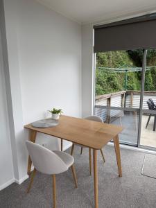 a wooden table and chairs in a room with a window at Stylish Private Apartment, Close to Ferry, Stadium, Parking in Wellington