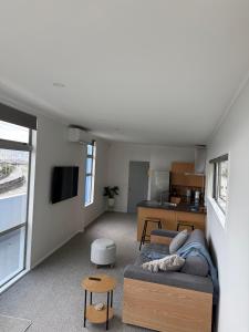 a living room with a couch and a kitchen at Stylish Private Apartment, Close to Ferry, Stadium, Parking in Wellington