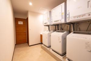 a laundry room with a bunch of washers and dryers at Juniya Myoko in Myoko