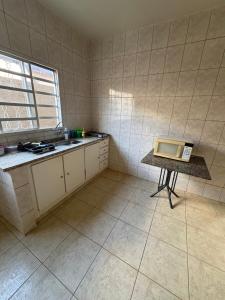 a kitchen with a table with a laptop on it at Pousada Dois Irmãos in Uberaba