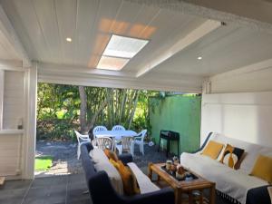a living room with couches and a table and chairs at Maison Désirée in Sainte-Anne
