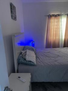 a bedroom with a bed with a blue light at Villa Rivera in Boca Chica
