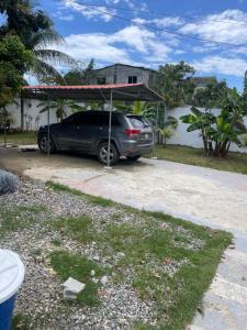 a car parked under a canopy in a driveway at Villa Rivera in Boca Chica