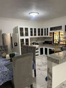 a kitchen with white cabinets and a table and chairs at Villa Rivera in Boca Chica