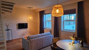 a living room with a couch and a table at B&B T'Rest - Park ter Rijst in Heikruis
