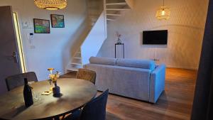 a living room with a table and a couch at B&B T'Rest - Park ter Rijst in Heikruis