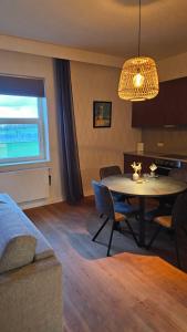a living room with a table and a dining room at B&B T'Rest - Park ter Rijst in Heikruis