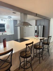 a kitchen with a island with chairs and a counter top at Welcome to Highland Shore in Ellenton +6 photos