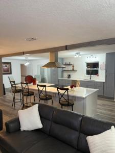a living room with a black couch and a kitchen at Welcome to Highland Shore in Ellenton