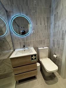 a bathroom with a sink and a toilet and a mirror at Casinha do Areeiro in Loulé