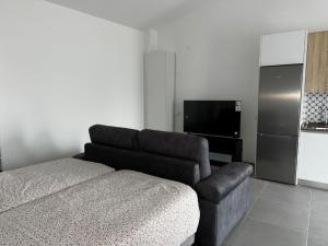 a living room with a couch and a television at Casinha do Areeiro in Loulé