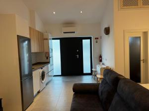 a living room with a couch and a kitchen at Casinha do Areeiro in Loulé