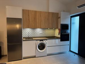 a kitchen with a washing machine in a kitchen at Casinha do Areeiro in Loulé