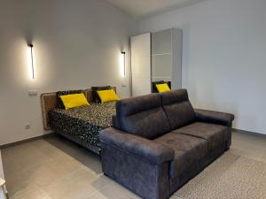 a bedroom with a couch and a bed with yellow pillows at Casinha do Areeiro in Loulé