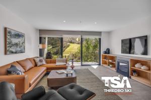 a living room with a couch and a table at Black Bear 402 in Thredbo