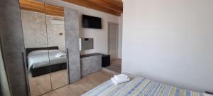 a small bedroom with a bed and a tv at La Locanda del Giardino in Lentate sul Seveso
