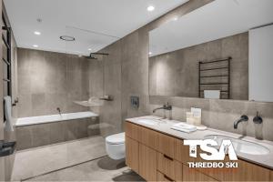 a bathroom with a sink and a toilet and a tub at Black Bear 402 in Thredbo +26 photos