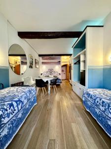 two beds in a room with a table and chairs at The Vernazza Main Plaza - Rooms & Suites in Vernazza
