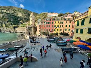 a group of people walking around a town with boats at The Vernazza Main Plaza - Rooms & Suites in Vernazza