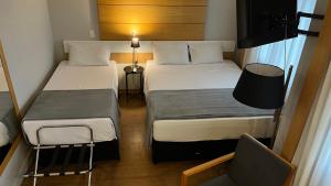 a small room with two beds and a chair at Suíte Aeroporto Congonhas Quarto Triplo in São Paulo +14 photos