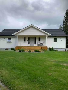 a white house with a wooden deck in a yard at Raufoss Villa Residence in Raufoss