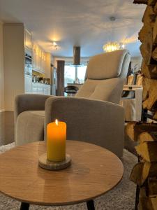a candle sitting on a table in a living room at Raufoss Villa Residence in Raufoss +26 photos