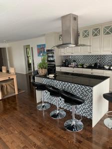 a kitchen with a black counter and black stools at Raufoss Villa Residence in Raufoss