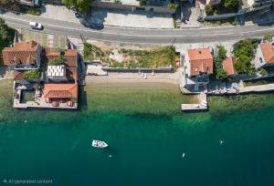 an overhead view of a house with a boat in the water at Seafront Villa with Private Pool & Beach in Kotor Bay, Villa Viborg in Kotor
