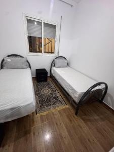 two beds in a room with a window at Le Nide d'azrou in Azrou