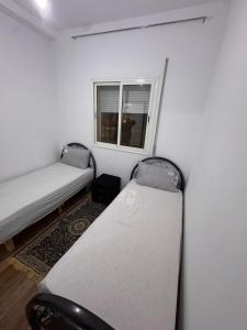 two beds in a room with a window at Le Nide d'azrou in Azrou +6 photos