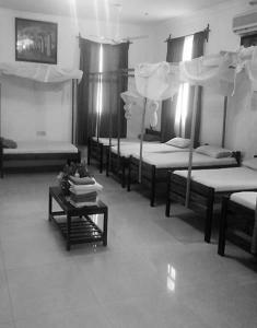 a room with four bunk beds and a table at Manch Lodge Vuga Zanzibar in Zanzibar City