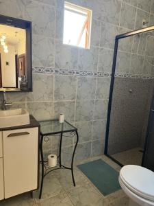 a bathroom with a shower and a sink and a toilet at Pousada Ju Haus in Navegantes