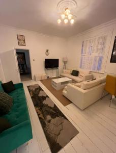a living room with two couches and a flat screen tv at Pet Friendly 2 Bed Ground Floor Apartment in Addlestone with Free Driveway Parking in Addlestone