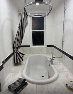 a white sink in a bathroom with a window at Pet Friendly 2 Bed Ground Floor Apartment in Addlestone with Free Driveway Parking in Addlestone +22 photos