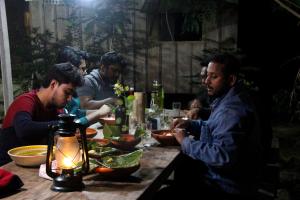 a group of men sitting at a table eating food at Hijoltola Camping & Resort in Kumāran