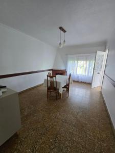 a dining room with a table and chairs in a room at Casa Blanca Verónica in Veronica +9 photos