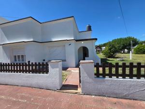 a white house with a fence in front of it at Casa Blanca Verónica in Veronica