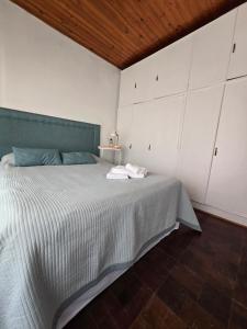 a bedroom with a large bed with white cabinets at Casa Blanca Verónica in Veronica
