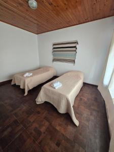 two beds in a room with a wooden ceiling at Casa Blanca Verónica in Veronica